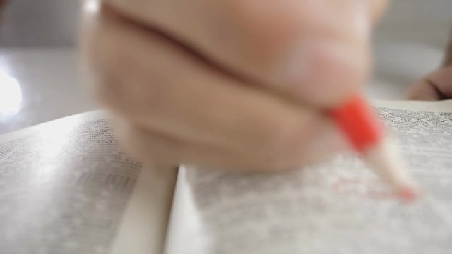 Close up shot of man's hands turning the pages of a reference book.  Finds the information.
