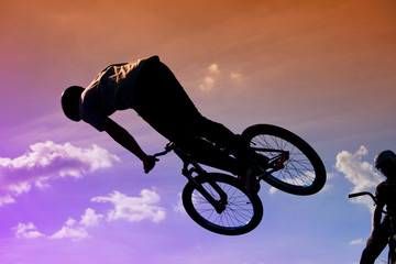 Bikers jumping on a ramp in the park