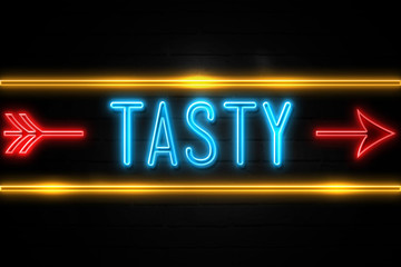Obraz premium Tasty - fluorescent Neon Sign on brickwall Front view