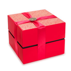 Red gift box with Chinese pin ornament for Happiness on top of a ribbon. Isolated on White Background.