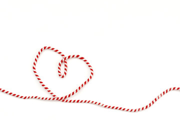 heart from red white ribbon on white