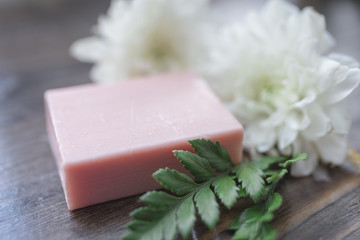Handmade soap closeup and white flowers in defocus