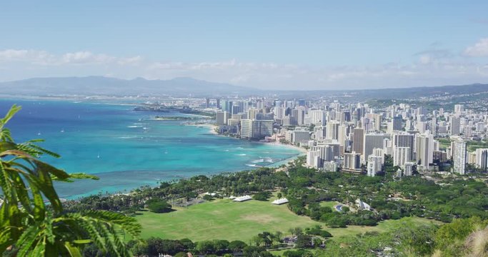 Waikiki Beach and Honolulu city against sky during sunny day. Cityscape and sea are seen from Diamond Head State Monument. It is famous landmark in Oahu.