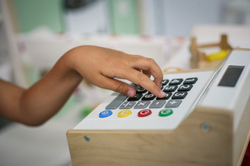 Close up of girl hand. Girl playing with register cash in playroom.