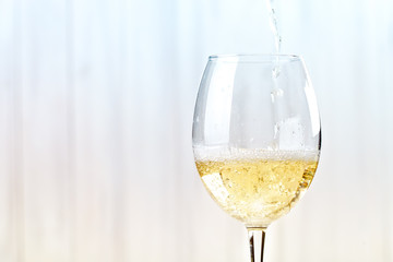 White wine poured in a glass.