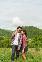 Couple of romantic lovers standing in nature . Asian handsome man and beautiful girl is travel , hipster people falling in love happiness time, vintage tone and lifestyle concept