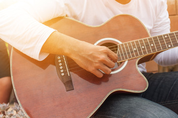 The country man is playing guitar in the garden, Handsome cowboy is playing folk song guitar.he...