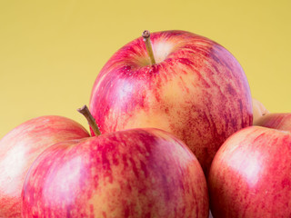 juicy red apples on yellow background