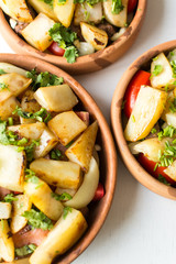 Potatoes, tomatoes, spices and meat roasted in ceramic pan