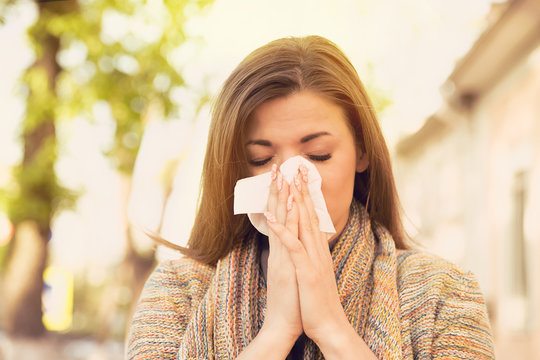 Woman With Allergy Symptoms Blowing Nose