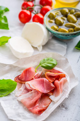 Prosciutto Olives olive oil mozzarella cheese tomatoes basil -  ingredients italian or mediterranean cuisine.