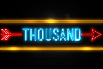Fototapeta premium Thousand - fluorescent Neon Sign on brickwall Front view