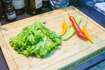 Red chilli pepper with lettuce on a wooden Chopping Board for Thai food preparing