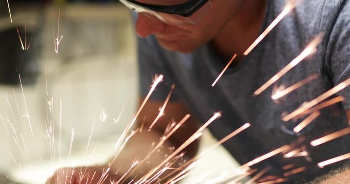 Craftsperson cutting metal in workshop