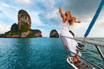 Joyful young woman portrait. Happy girl stand on deck of sailing yacht, have fun discovering...