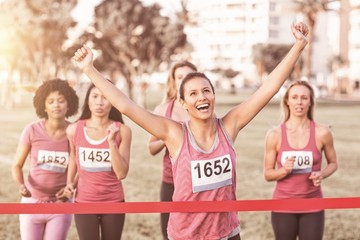 Cheering brunette winning breast cancer marathon