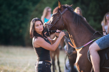 Obraz premium Woman with her horse outside at sunset.