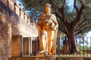 Stone statue of a medieval knight king in Alcazar de los Reyes Cristianos or Castle of the Christian Monarchs in the sunny day, Cordoba, Andalusia, Spain