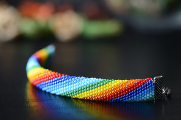 Handmade crocheted bracelet rainbow colors on a dark background