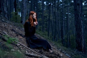woman in a long dress in the woods, darkness