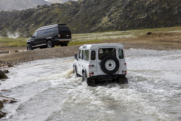 two vehicles fording river in nature park  landmannalaugar in iceland