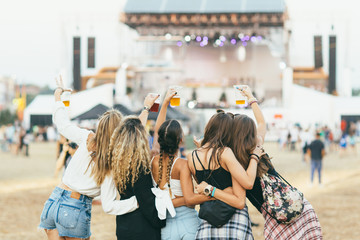 Friends having fun at music festival. Back view 