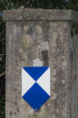 Denkmalschutz, Schild auf altem Betonpfosten