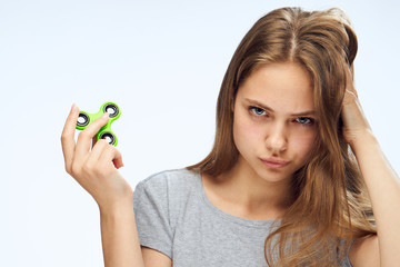 woman holds a spinner on white isolated background, portrait