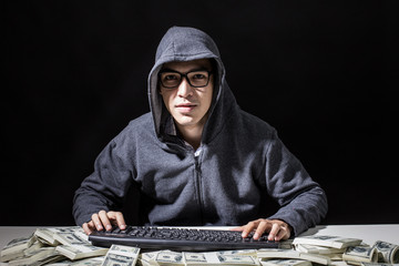 Hacker get a lot of Money that Hacking from online in the dark, Man with Hacker Concept.