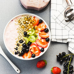 Vegetarian smoothie bowl with berries,nuts and green buckwheat, ingredients and blender. Top view.