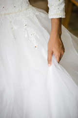 Bridal white dress close up crop hand holding pulling up 