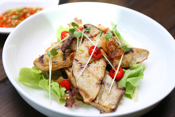 Grilled King Oyster Mushroom , Eryngii slices with sunflower sprout and green oak lettuce on white plate