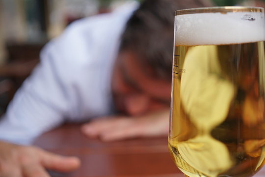 Young drunk man sleeping on the table in a bar