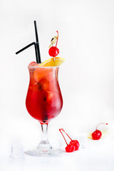 Front view of cold fresh tropical red cocktail in a tulip glass decorated with a slice of orange, cherry and straws on light background