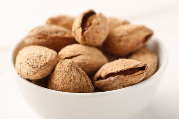 Closeup shot of almond in shell in a white ceramic bowl