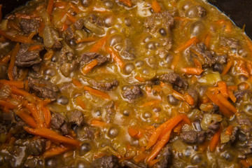 Rice and meat are fried in a frying pan.