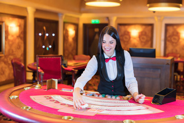 Cute lady casino dealer at poker table.