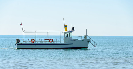 Fototapeta na wymiar Boat or ship navigating on blue Black Sea water, entertaiment yacht