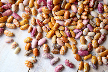 Pinto beans on wooden background. Different colors of dried pinto beans.