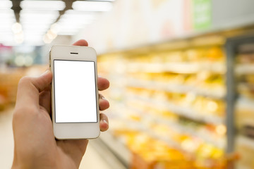 Man hand holding mobile smart phone on Supermarket blur background, business concept