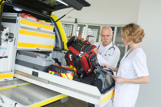 ambulance nurse and doctor packing gear in the vehicle