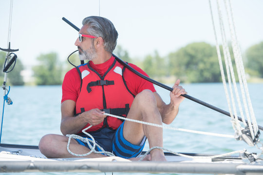 handsome mature man sailing on hobby catamaran