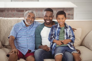 Smiling multi-generation family sitting together on sofa