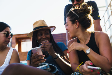 Friends with smart phones relaxing outside