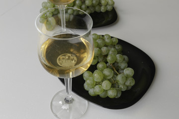 Wine and Grapes. Young White Wine and Green Grapes isolated on White Background