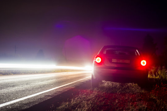 Car Parked On The Road Late At Night