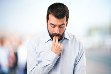 Handsome man with beard making vomiting gesture on unfocused background