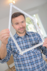 man holding a house shaped ruler