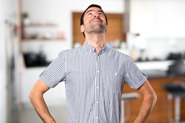 Handsome man looking up inside house