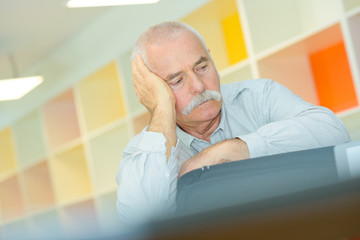 Fototapeta premium elderly man with hand on his temple has a headache